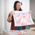 Illustrator Steffi Bauer folds a tea towel in her office