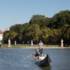 Gondolier standing with oar in hand on the gondola with guests on the Nymphenburg Canal in Munich