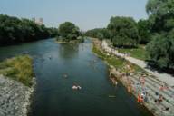 Des personnes se baignent dans la rivière Isar à Munich sous le soleil.