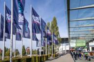 Several flags with the EXPO REAL logo fly in front of the Munich Trade Fair Centre.