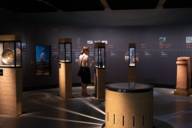 A woman looks at the display cases with artefacts in the State Archaeological Collection in Munich.