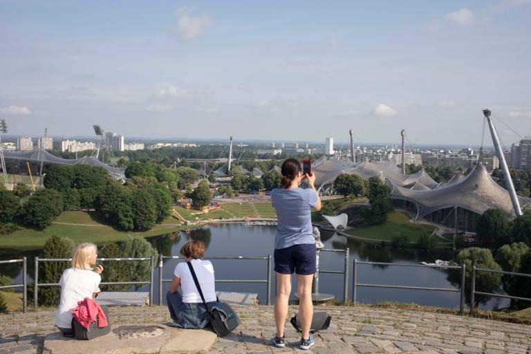 Tres turistas en el mirador de Olympiaberg con vistas al parque y al interior.